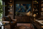 Blue Gold Modern Abstract Triptych Printable Wall Art Set of 3 showcased in a luxurious home library above a dark walnut sideboard. Blue and gold abstract three-panel gallery wall prints framed in natural wood with subtle white matting complement leather armchair, built-in bookshelves, Persian rug, brass lamp, whiskey cart, and warm ambient lighting. Printable wall art bundle for elegant interiors.