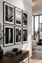 Modern monochrome wall art display with six printable black and white photography prints from the Timeless Fine Art collection styled in a contemporary American apartment hallway with elegant interior design.