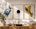 Designer abstract watercolor wall décor in rich blue, black and golden yellow tones showcased against sophisticated mauve walls inside a contemporary American reading lounge. Premium gold wood frames with oversized white mat boards transform the artwork into an elegant gallery wall, beautifully coordinated with brass accents, custom shelving, fresh floral arrangements, luxury furniture and soft afternoon sunlight filtering through linen curtains.