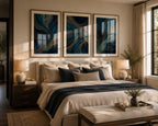 Blue Gold Modern Abstract Triptych Printable Wall Art Set of 3 displayed in a sophisticated contemporary bedroom bathed in warm afternoon sunlight. Three blue and gold abstract 3-panel gallery wall prints in elegant natural oak wood frames with refined white matting hang above a floating walnut console. Designer table lamps and a sculptural floor lamp cast a soft ambient glow, complementing a cream sectional sofa, textured throw blankets, indoor plants, ceramic décor, and warm oak flooring. The golden e