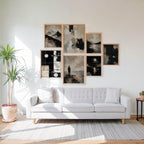 Abstract Beige Black White Neutral Printable Wall Art Kit Set of 9 displayed as an elegant asymmetrical gallery wall featuring 7 abstract prints in a simple American living room. Warm oak frames, soft beige walls, neutral furnishings, and natural daylight create a clean, inviting atmosphere while highlighting the original black, white, and beige tones of this Neutral Tones Abstract Gallery Wall Bundle. Perfect inspiration for modern apartment decor, minimalist living room wall art, Scandinavian home styling